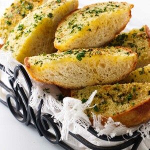 A wroght iron basket filled with hot garlic bread.