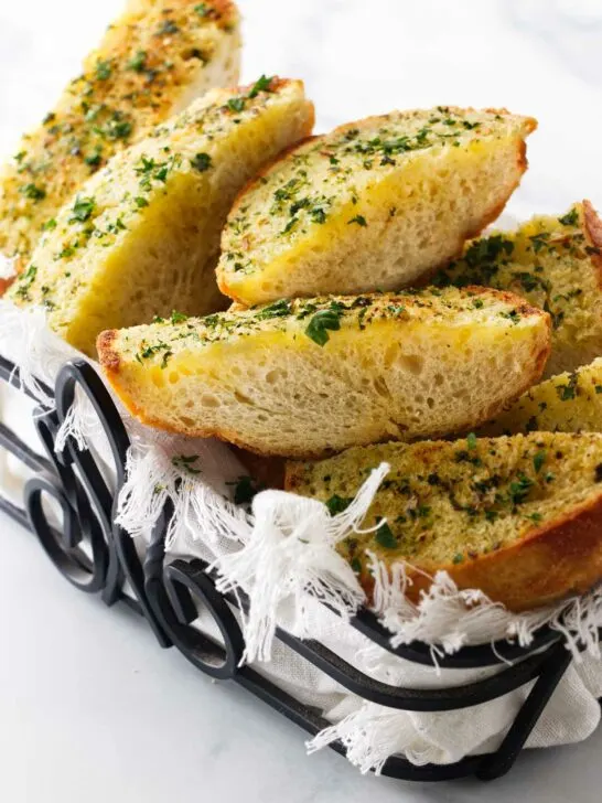 A wroght iron basket filled with hot garlic bread.