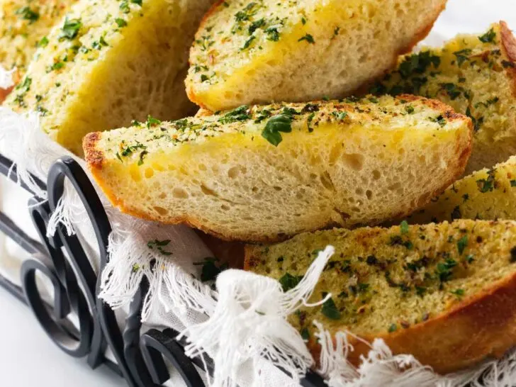 A wroght iron basket filled with hot garlic bread.