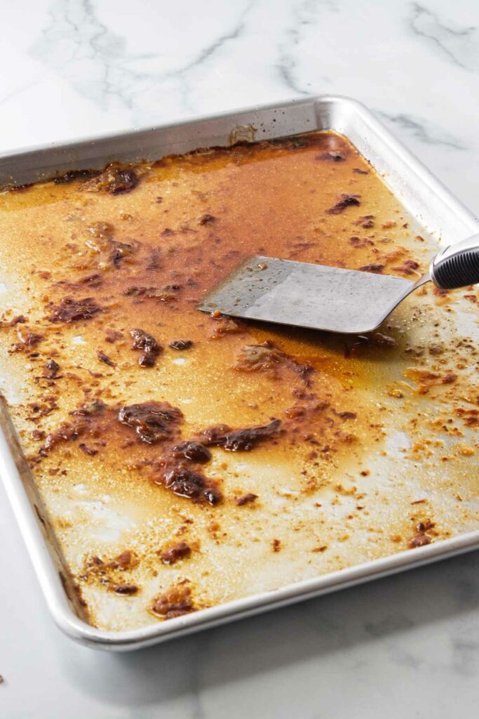 A pan with turkey drippings and a spatula.