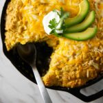 A skillet with a green chili tamale pie with cornbread topping.