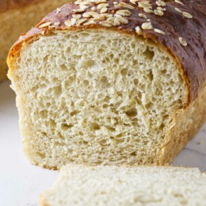 A loaf of oatmeal bread sliced in half to show the interior crumb.