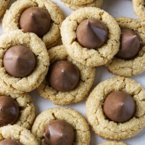 Several peanut butter blossoms on a white counter.