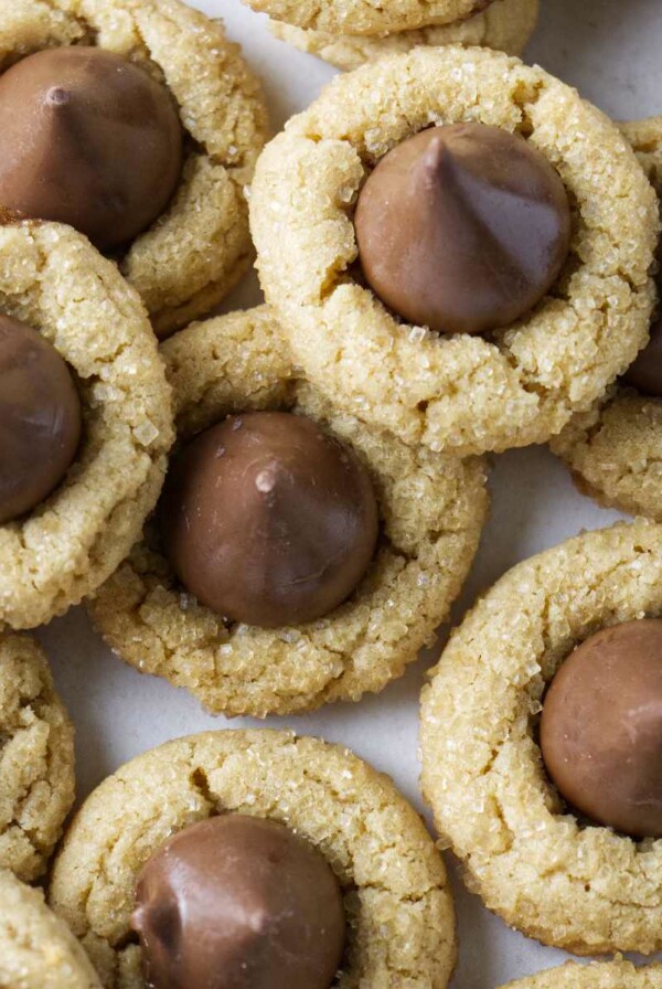 Several peanut butter blossoms on a white counter.