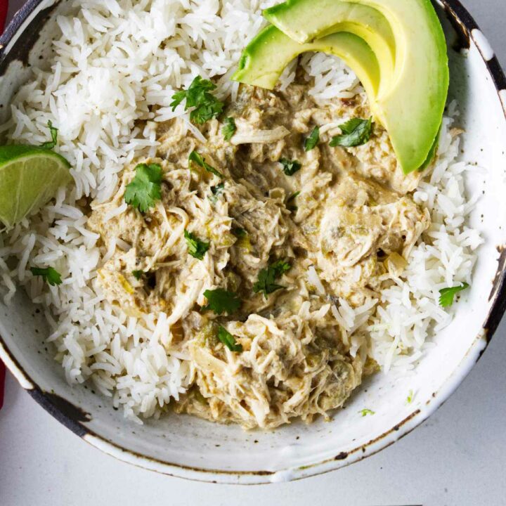 A bowl of green chicken chile over white rice.