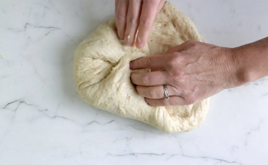 Shaping bread dough into a loaf.