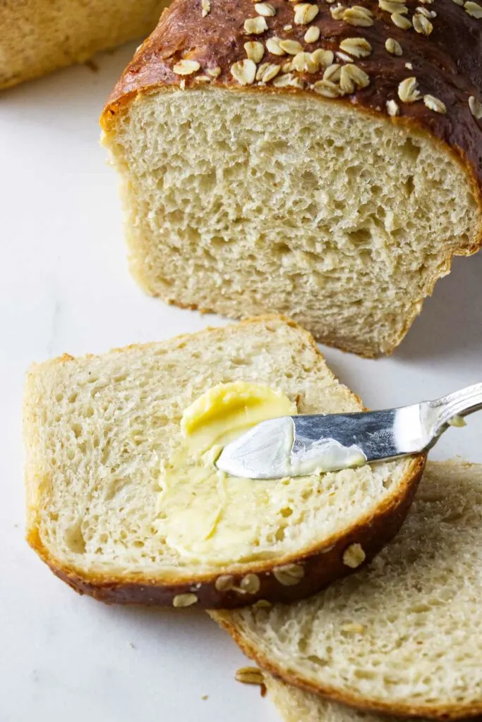 Spreading butter on a slice of bread.