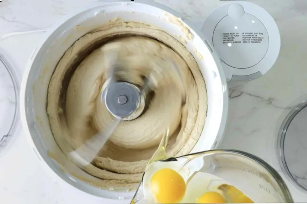 Adding eggs to cookie dough batter.
