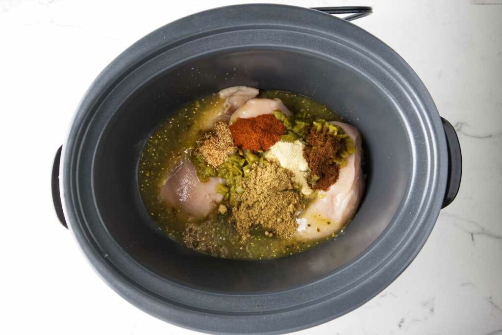 Chicken in a slow cooker with green chile and spices.
