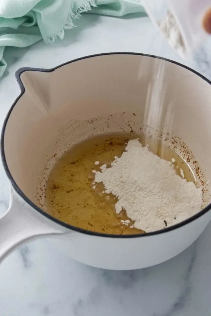 Adding flour to turkey drippings to make gravy.