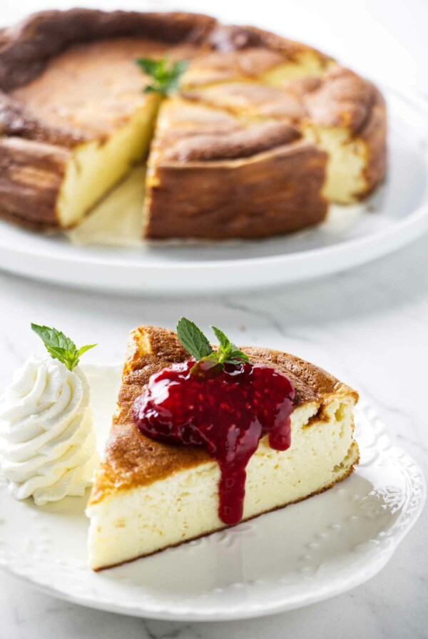 A slice of creamy yogurt cake behind a plate with more cake.