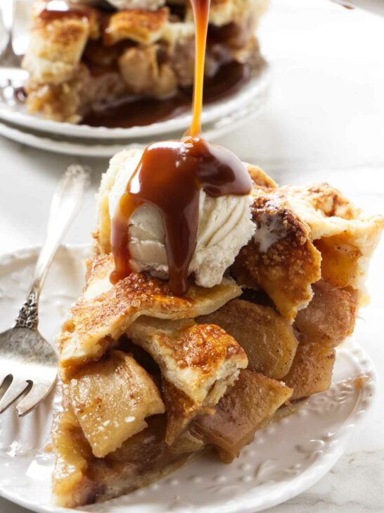 Drizzling caramel sauce over a scoop of ice cream on top of a slice of pie.
