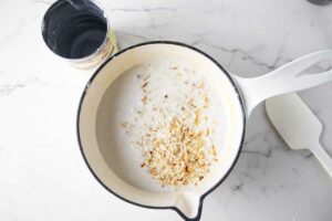 Heating coconut milk in a saucepan.