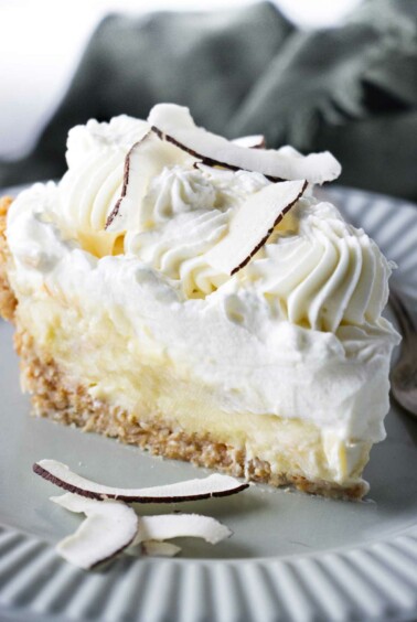 A pie with coconut pastry cream and whipped cream on top.