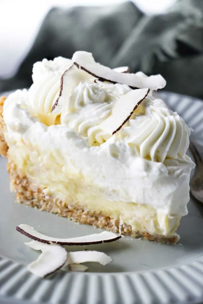 A pie with coconut pastry cream and whipped cream on top.