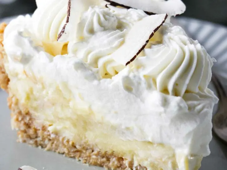 A pie with coconut pastry cream and whipped cream on top.