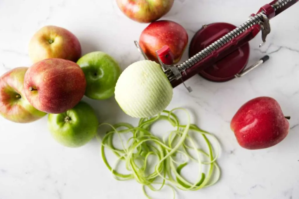 Using an apple peeler and corer to peel apples.