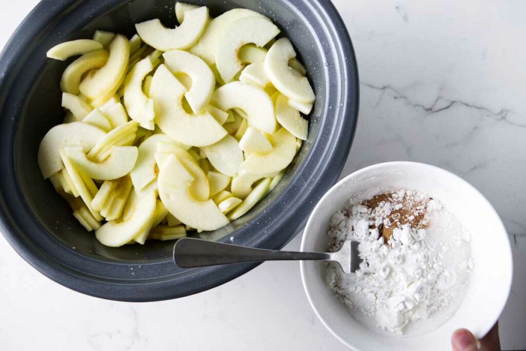 Blending sugar, spices, and cornstarch together before tossing with apples in a crockpot.