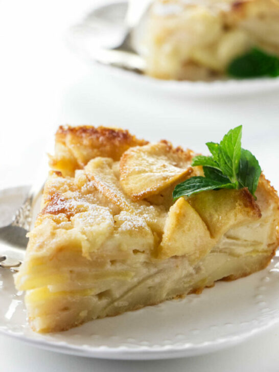 A slice of French apple custard cake on a plate.