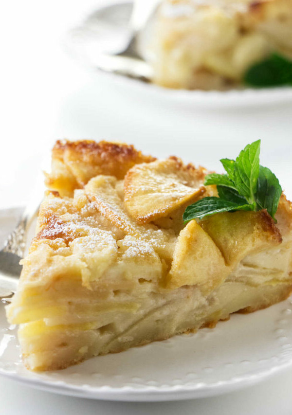 A slice of French apple custard cake on a plate.