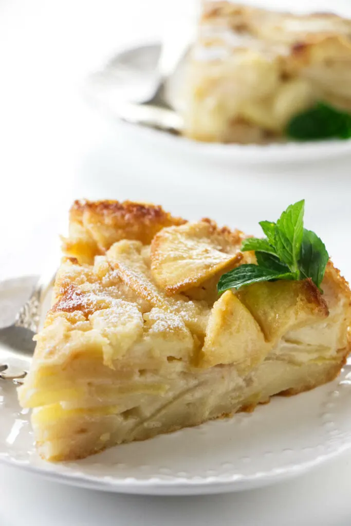 A slice of French apple custard cake on a plate.
