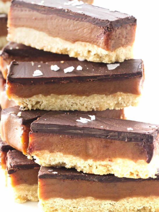 A stack of cookie bars with salt flakes sprinkled on top.