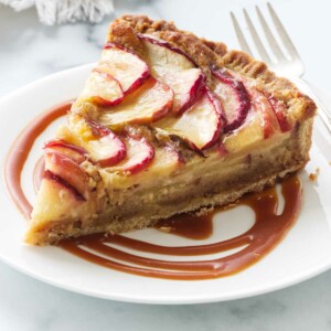 A slice of a frangipane tart on a plate.