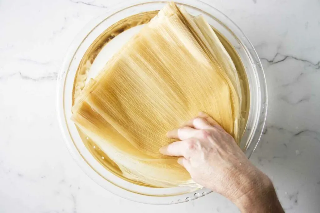 Soaking corn husks in water.