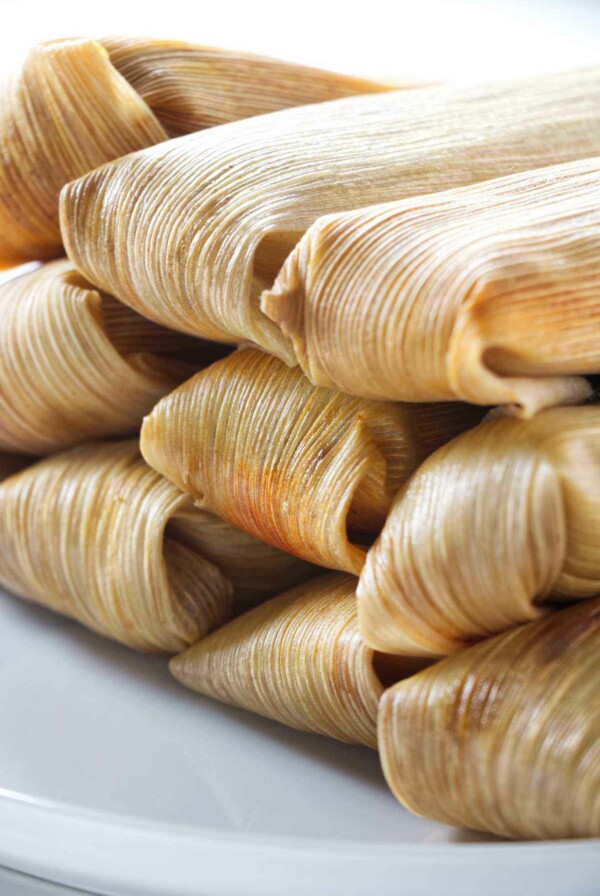 Several tamales wrapped in corn husk.