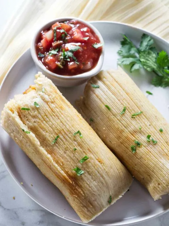 Two tamales on a plate.