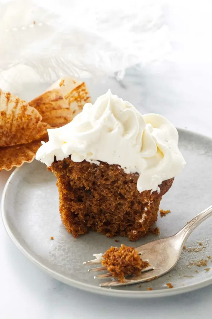A serving of pumpkin cupcake with a bite on a fork.