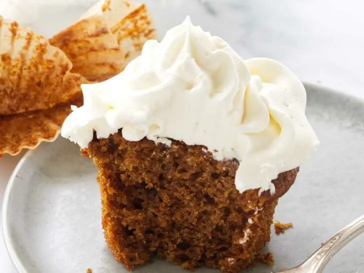 A serving of pumpkin cupcake with a bite on a fork.