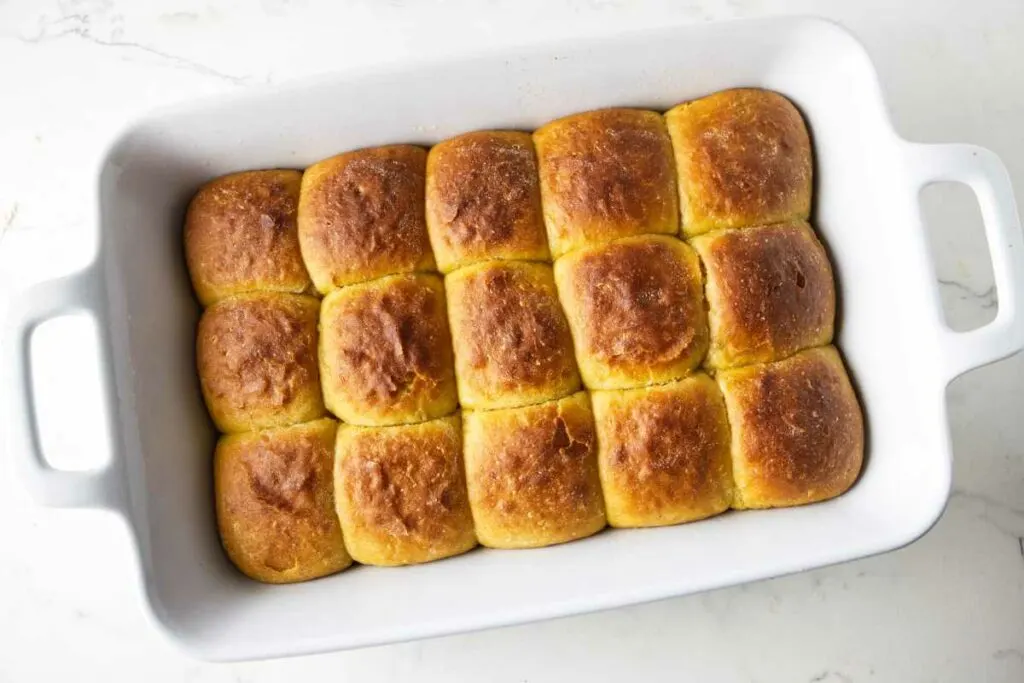 Golden brown dinner rolls in a 13 x 9 inch baking dish.