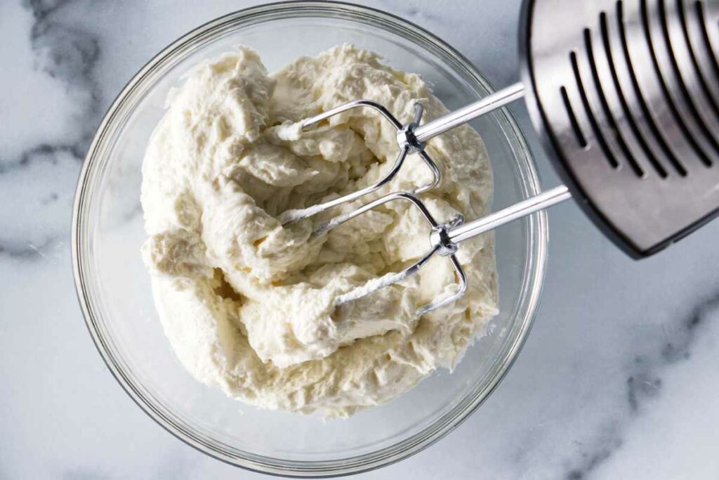 Mixing goat cheese with cream cheese.