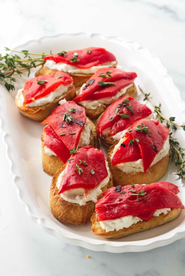 Eight bruschetta with red pepper and goat cheese.