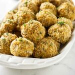 A serving dish filled with crispy potato croquettes.