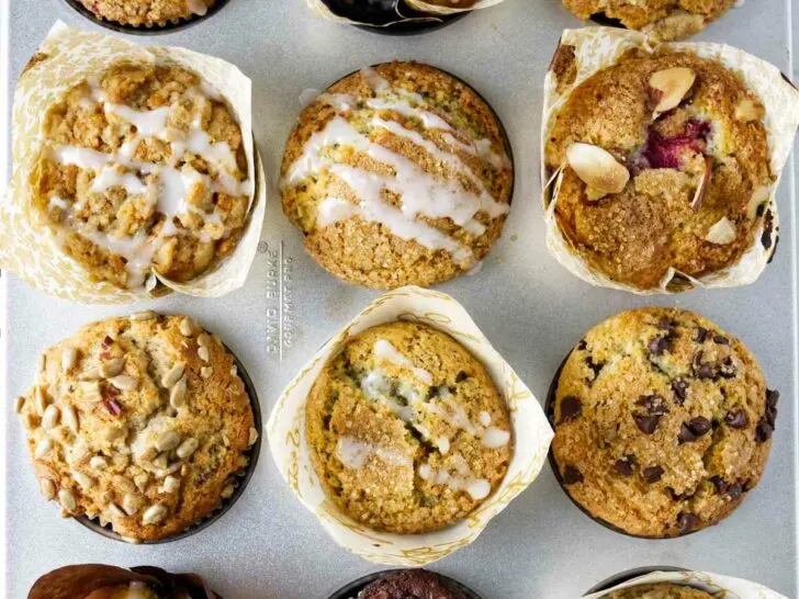 A muffin pan filled with twelve different types of muffins.
