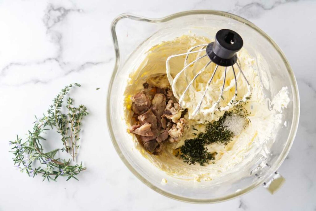A mixing bowl and whisk with whipped butter, roasted bone marrow herbs and salt.