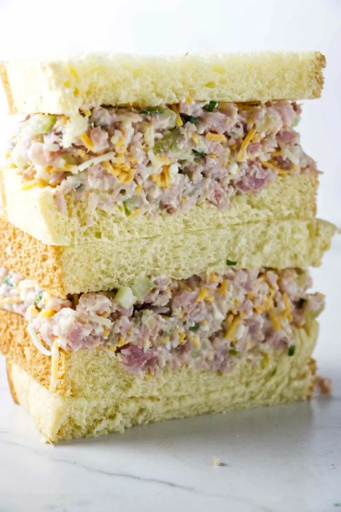 A ham salad sandwich stacked on a white counter.