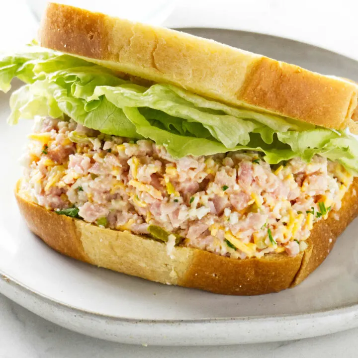A ham salad sandwich on white bread with lettuce.