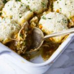 Scooping a serving of chicken and dumpling casserole.