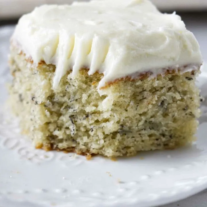 A slice of banana cake topped with cream cheese frosting.
