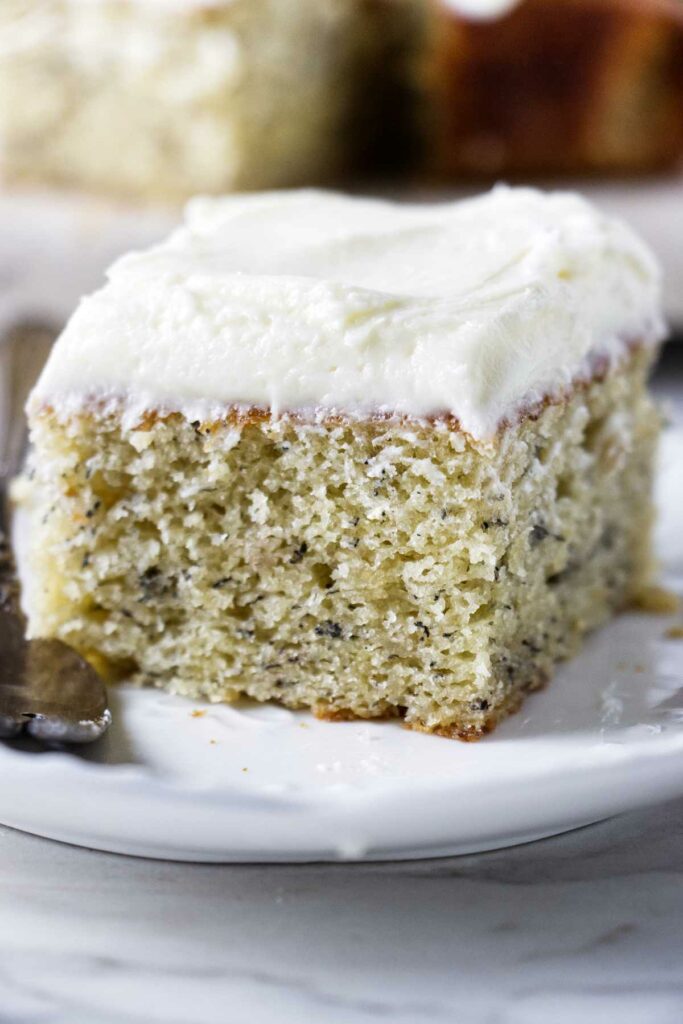 A slice of banana cake with lemon cream cheese frosting.