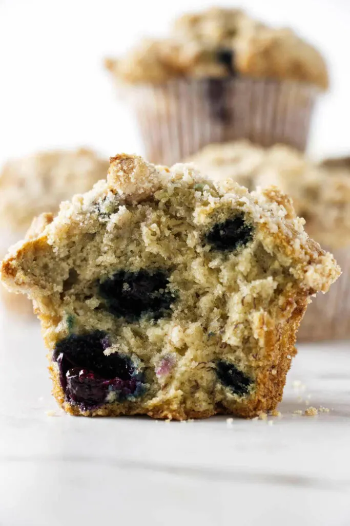 A banana blueberry muffin split open to show the tender crumb in the center.