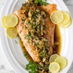 Trout almandine on a serving platter with lemon slices.