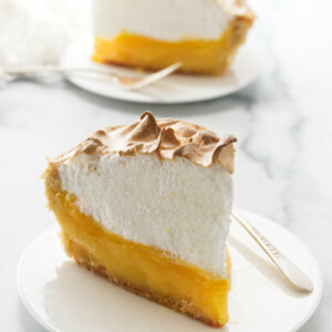 Two slices of pie on white plates.