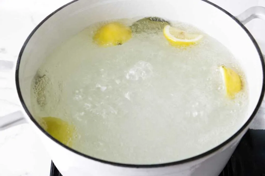 Boiling water with lemon and herbs.