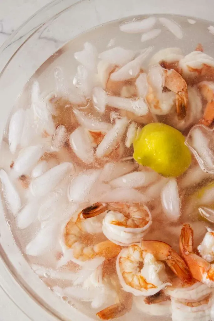 Dunking boiled shrimp in ice water.
