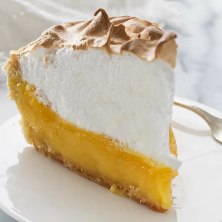 A tall meringue on top of a lemon pie.