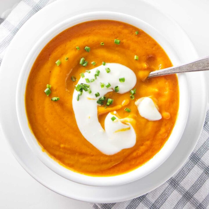 A bowl of carrot soup with a dollop of yogurt on top.